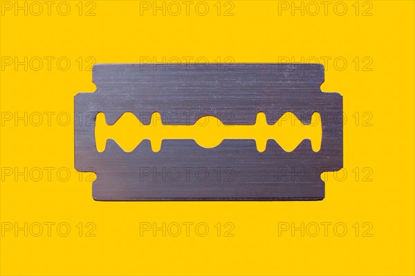 Razor blade against yellow background