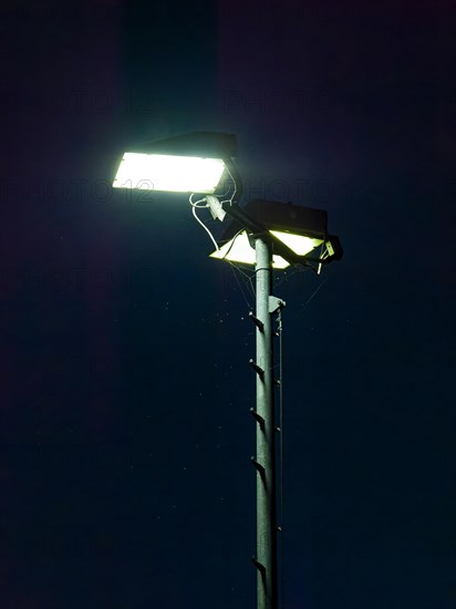 Spotlights on the football pitch in the night sky