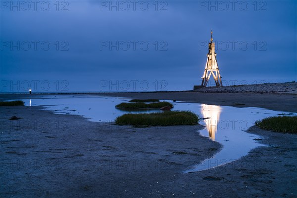 Kugelbake illuminated with water reflection at dusk