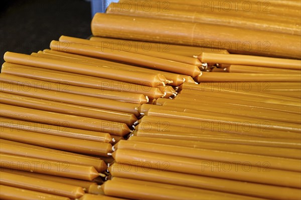 Pile of new yellow wax candles used in churches