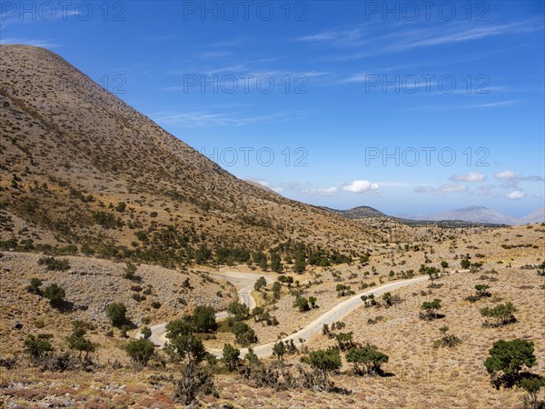 Narrow road winds through karst mountain landscape at Psiloritis