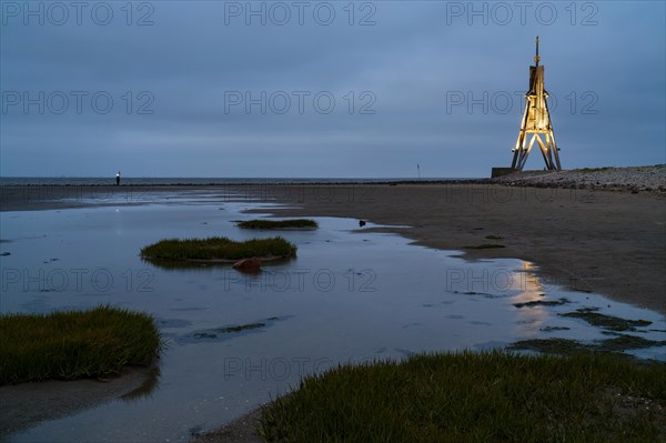 Kugelbake illuminated with water reflection at dusk