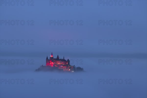 Hohenzollern Castle with Christmas lights in the fog from the Zeller Horn