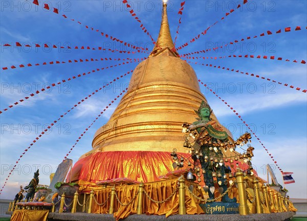 Statue of green-skinned Thai angel holding roll with message in Thai