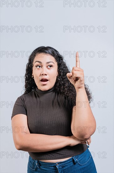 Beautiful latin girl amazed pointing up isolated. Young woman with an idea raising finger isolated