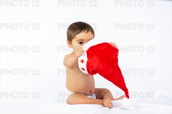 A baby boy with a red Christmas hat on a white background