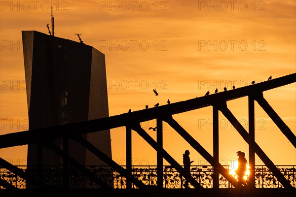 The sun rises behind the European Central Bank