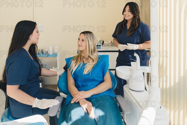 Woman smiling during her dental treatment at dentist. Females dental doctors treating a female patient in hospital