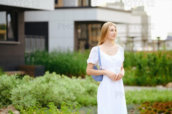 Young woman waiting for taxi or a bus in townhouse