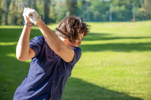 Female Golfer Making a Golf Swing in a Sunny Day in Switzerland