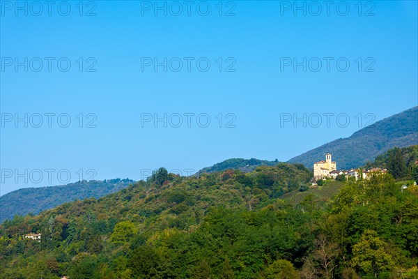 Church in Castelrotto and Village on Mountain Range and Valley with Sky in a Sunny Summer Day in Malcantone