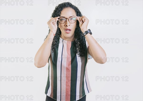 Latin girl taking off her glasses looking a promotion. Surprised woman taking off glasses isolated. Amazed afro girl taking off glasses by a promotion