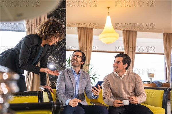 Start up meeting between woman and two men in the hall of an hotel