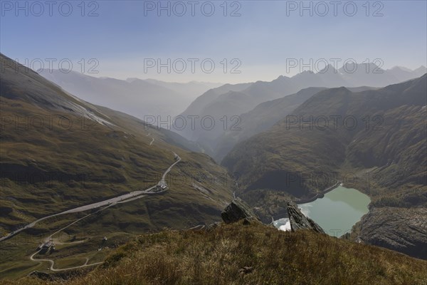 Mountain panorama with Grossglockner High Alpine Road and reservoir in autumn mist