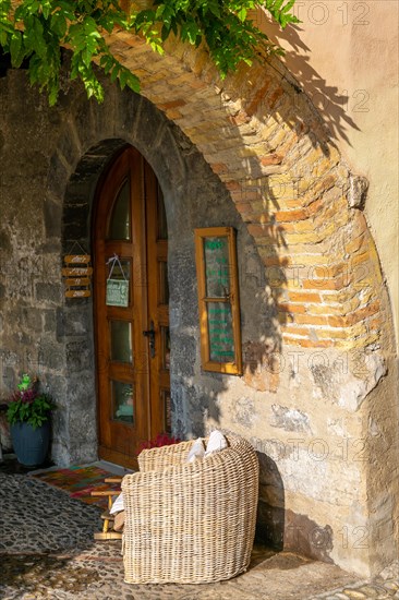 Beautiful Old Corner Below an Arch on a Narrow Street with a Armchair and Entrance Door with Sunlight in Bissone