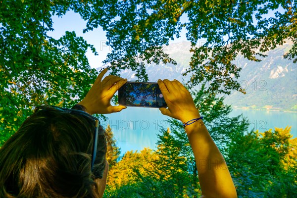 Woman Photographing Lake Brienz with Mountain in Brienz