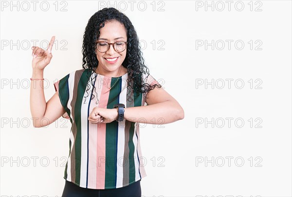 Happy young woman looking at hand watch isolated. Girl in glasses measuring time with hand watch