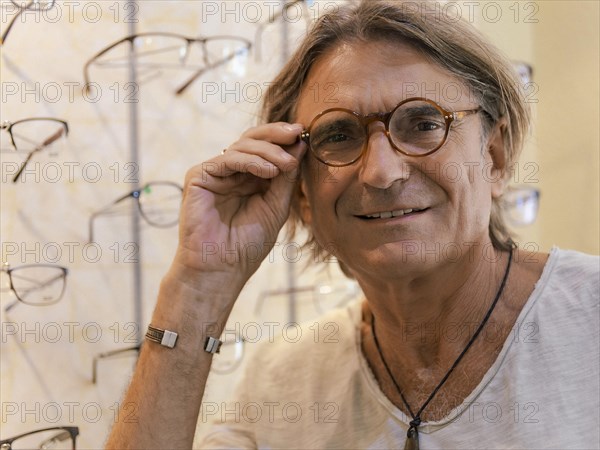 Man at optician trying on new glasses