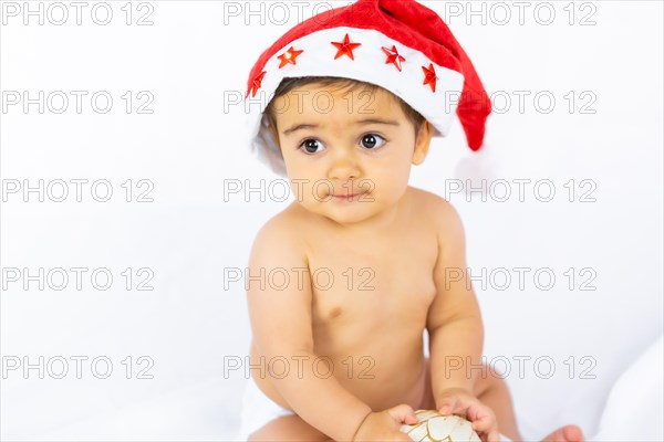 A baby boy with a red Christmas hat on a white background