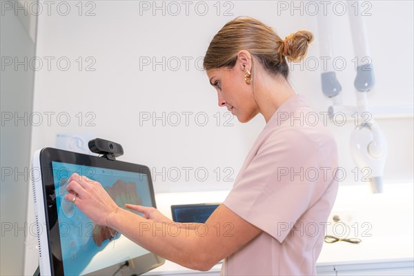 Dentist using modern technology to analyse the scan results in a clinic