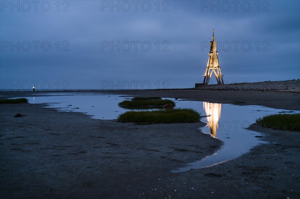 Kugelbake illuminated with water reflection at dusk