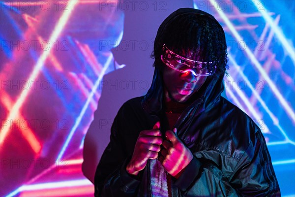 Studio portrait with purple and blue neon lights of a modern man with futuristic glasses