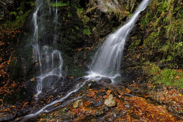 Mountain stream and waterfall in autumn forest