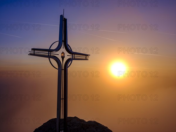 Summit cross Hoher Goell in the fog at sunrise