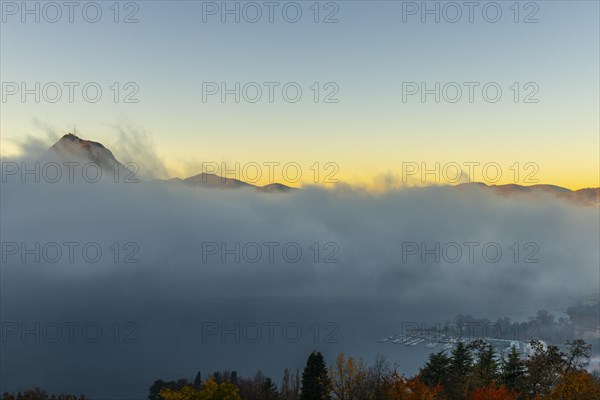 Mountain Peak San Salvatore Above Cloudscape and Lake Lugano with Sunlight and Clear Sky in City of Lugano