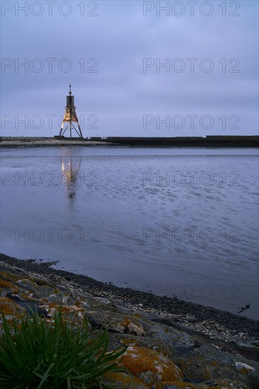 Kugelbake illuminated with water reflection at dusk