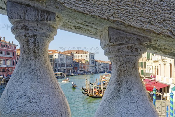 View through the stone railing of the Rialto Bridge onto the Grand Canal