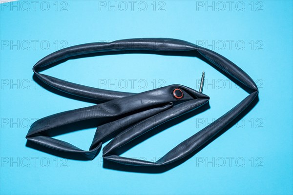 Top view of a flat bicycle tube against a blue background