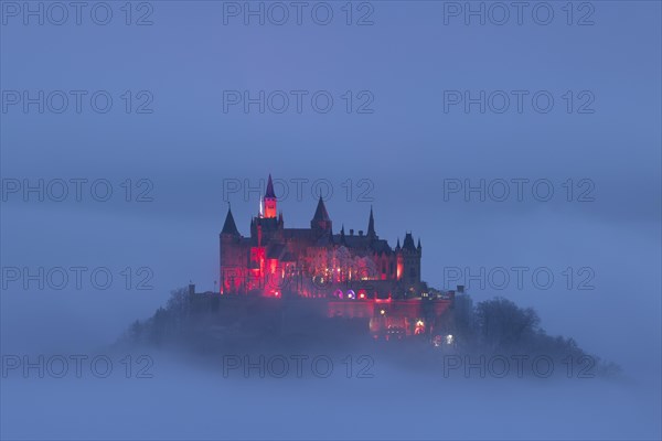 Hohenzollern Castle with Christmas lights in the fog from the Zeller Horn