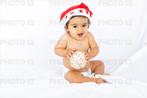 A baby boy with a red Christmas hat on a white background