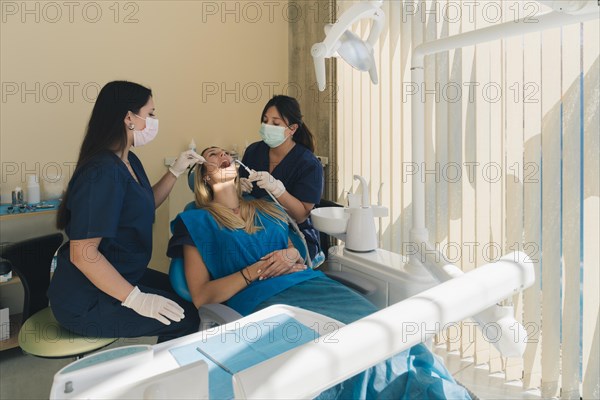 Dentist examining woman patient teeth and having a dental checkup at dental clinic