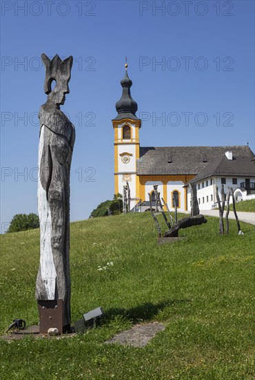 Wooden sculptures at the Stations of the Cross on Kirchberg with parish church