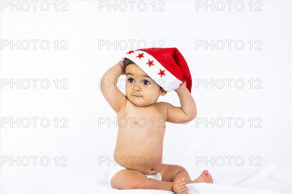 A baby boy with a red Christmas hat on a white background