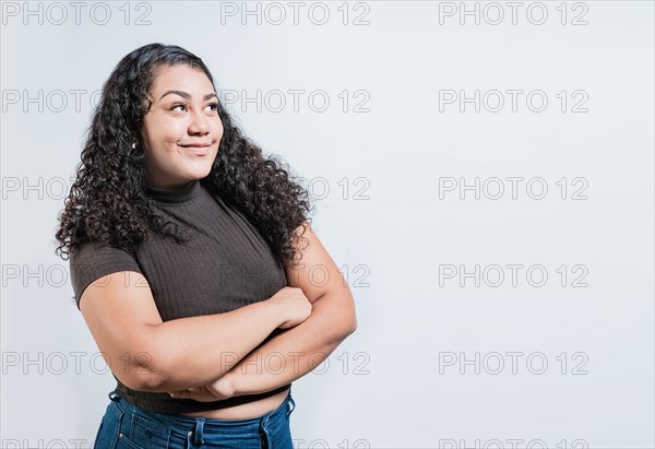 Attractive thoughtful girl with crossed arms isolated. Latin girl imagining with crossed arms. People thinking things on isolated background