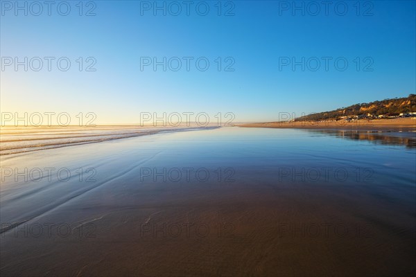 Atlantic ocean sunset with surging waves at Fonte da Telha beach