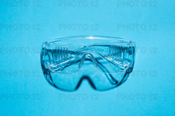 Top view of plastic goggles against a blue background