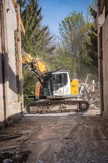 Yellow Liebherr crawler excavator recycling on demolition site