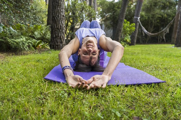 Happy smiling woman lying on yoga blocks while looking at camera