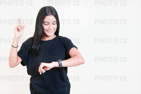 Happy latin girl looking at hand watch isolated. Smiling teen girl looking at hand watch isolated