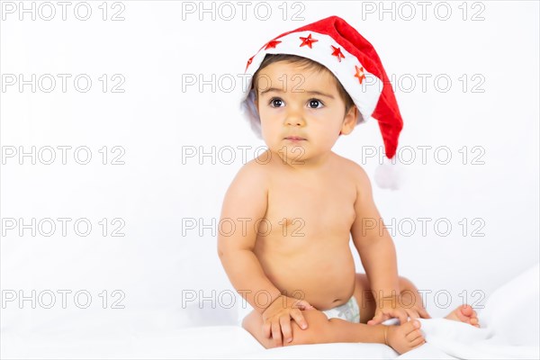 A baby boy with a red Christmas hat on a white background