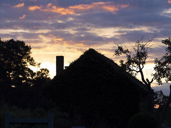 Colourful sky over small house with chimney in the morning