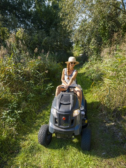 Woman driving lawn mower