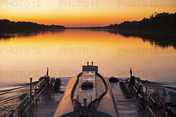 Boat sailing on the on the Mamore River at sunset in the Amazon basin