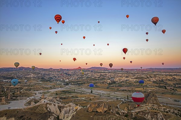 Hot air balloons flying over Cappadocia at sunrise