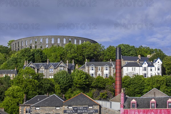 Oban Distillery and McCaig's Tower on Battery Hill overlooking the city Oban