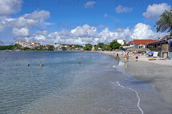 Tourists on sandy beach at Anse Mitan